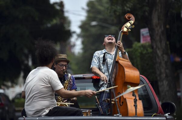The Maroto Jazz Trio band, made up of Diego Maroto on Saxophone, Jorge Molina on double bass and Edy Vega on drums, perform atop a van through neighborhoods in Mexico City, on August 29, 2020, amid the new coronavirus pandemic.  - Sputnik Africa
