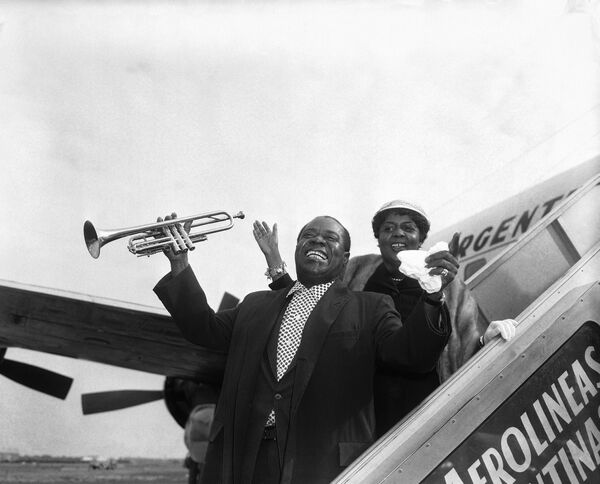 Jazz artist Louis &quot;Satchmo&quot; Armstrong, accompanied by his wife, prepares to take off from Idlewild Airport, New York, October 27, 1957, for a concert tour of five South American countries.    - Sputnik Africa