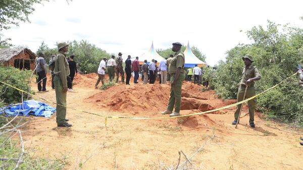 Police officers stand near a cordon at the scene where police are exhuming bodies of victims of a Christian cult that has led to the death of dozens of followers at a forest in Shakahola area, outskirts of Malindi town, Kenyan Coast Tuesday, April 25, 2023.  - Sputnik Africa