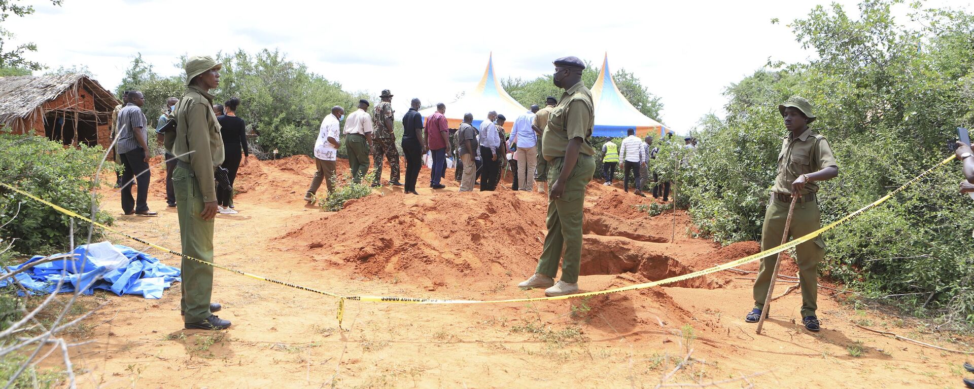 Police officers stand near a cordon at the scene where police are exhuming bodies of victims of a Christian cult that has led to the death of dozens of followers at a forest in Shakahola area, outskirts of Malindi town, Kenyan Coast Tuesday, April 25, 2023.  - Sputnik Africa, 1920, 01.05.2023