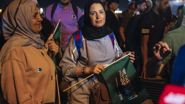 In this photo provided by Saudi Ministry of Media, evacuees carry Saudi flags as they arrive at Jeddah Port, Saudi Arabia, Monday, April 24, 2023, after being evacuated from Sudan to escape the conflict. - Sputnik Africa