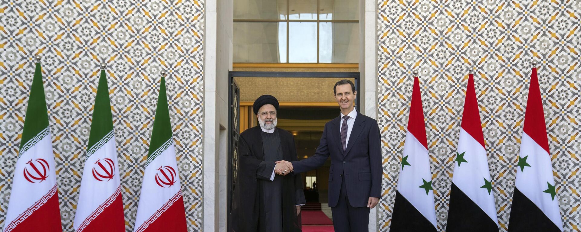 In this photo released by the official Facebook page of the Syrian Presidency, Syrian President Bashar Assad, right, shakes hands with Iranian President Ebrahim Raisi in Damascus, Syria, Wednesday, May 3, 2023. - Sputnik Africa, 1920, 04.05.2023