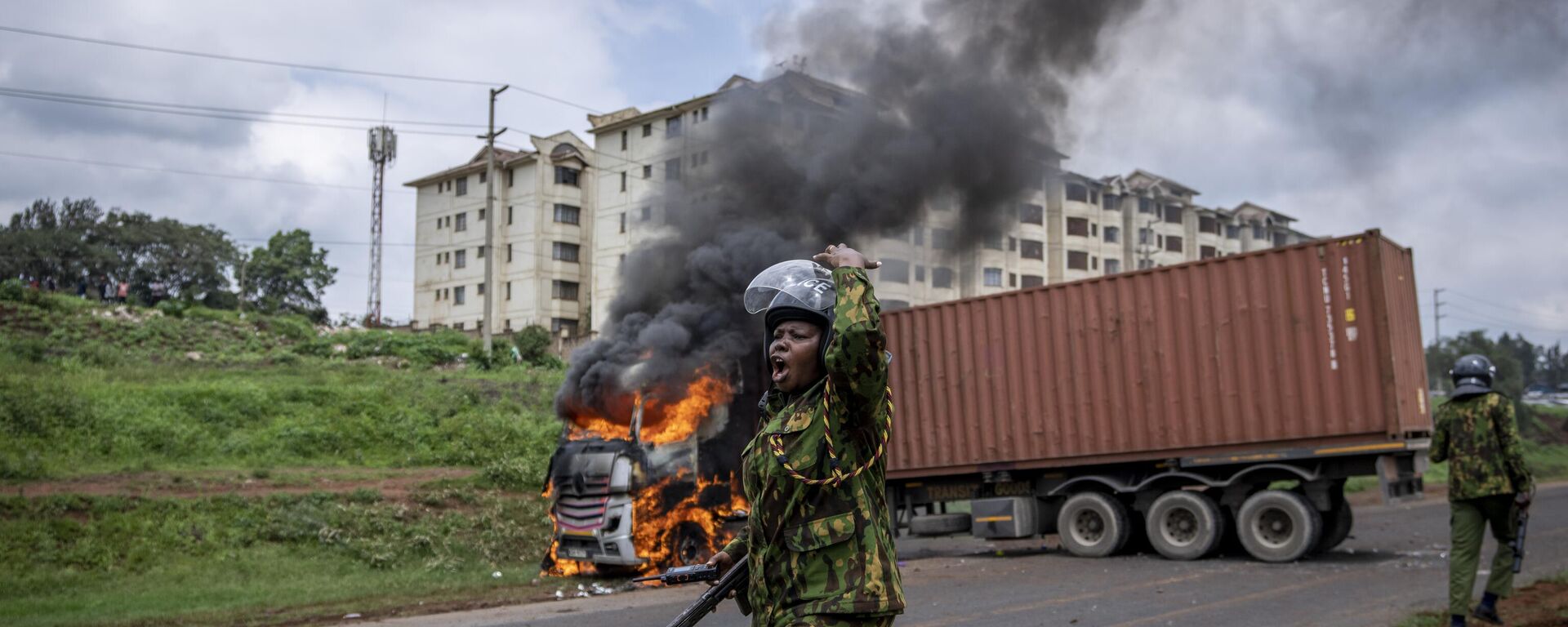 A policewoman calls for reinforcements after opposition protesters set fire to a truck in the Kibera slum of Kenya's capital Nairobi - Sputnik Africa, 1920, 04.05.2023