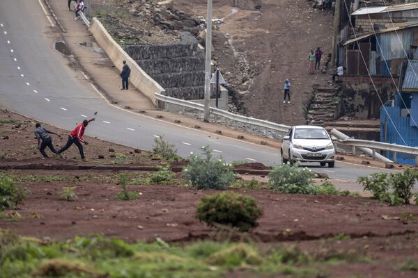 An opposition protester throws a rock at a passing vehicle during clashes in the Kibera slum of the capital Nairobi, Kenya, Tuesday, May 2, 2023.  - Sputnik Africa