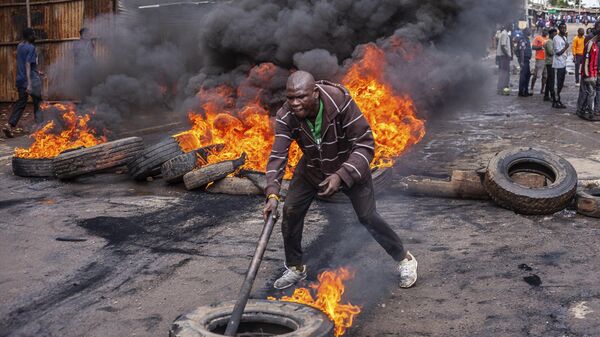 Protester in front of fire - Sputnik Africa