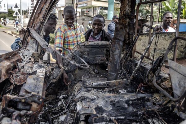 Bystanders observe a bus burnt by protesters during riots in Nairobi on May 2, 2023. - Sputnik Africa