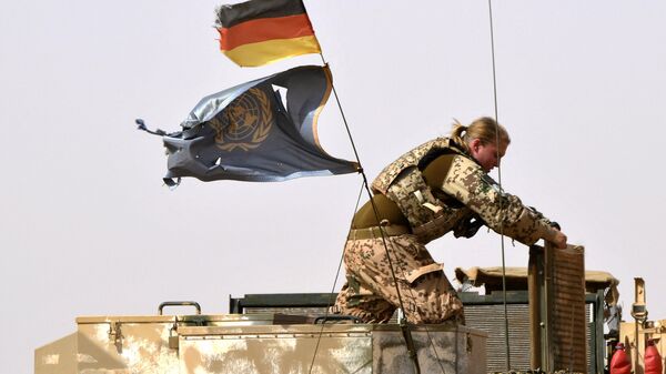 In this file photo taken on August 03, 2018 a German soldier from the parachutists detachment of the MINUSMA (United Nations Multidimensional Integrated Stabilization Mission in Mali) searching for IED (improvised explosive device) works next to a German and the UN flag during a patrol on the route from Gao to Gossi, Mali - Sputnik Africa