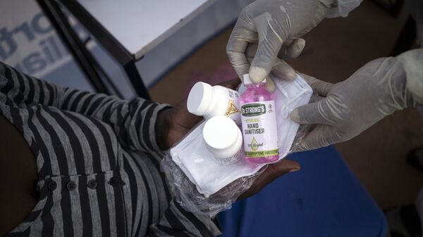 Nurse Nomautanda Siduna gives hand sanitizer and antiretroviral drugs to a patient in Ngodwana, South Africa, Thursday, July 2, 2020 - Sputnik Africa