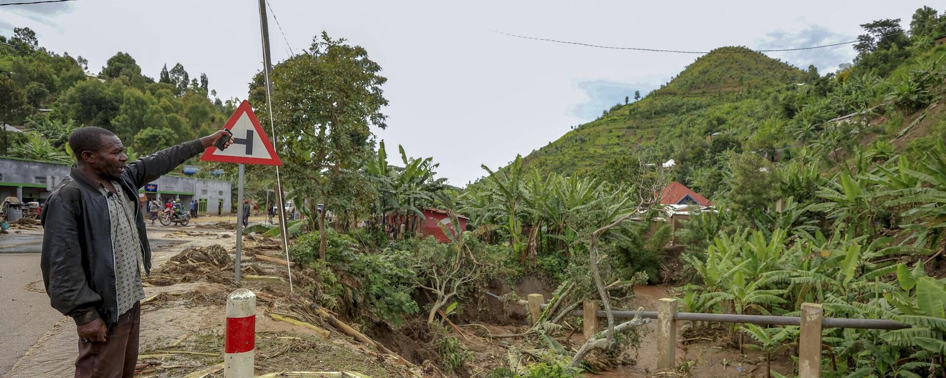 A man stands by floodwater debris in Karongi District, western Rwanda, Wednesday, May 3, 2023.  - Sputnik Africa, 1920, 07.05.2023