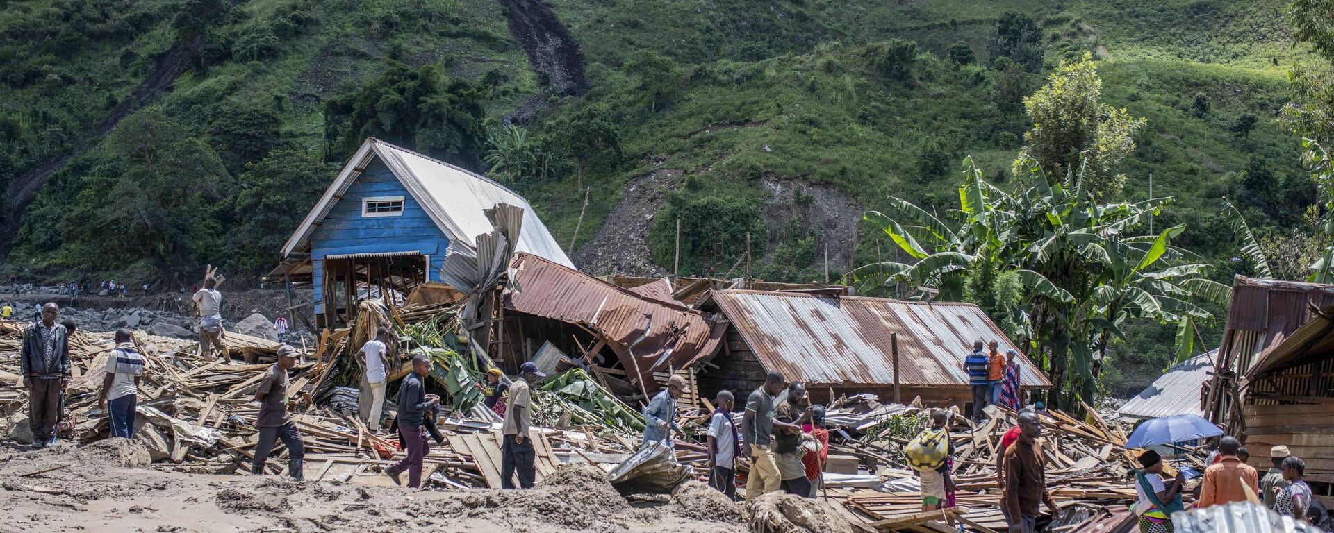 People walk next to houses destroyed by the floods in the village of Nyamukubi, South Kivu province, in Congo Saturday, May 6, 2023. - Sputnik Africa, 1920, 08.05.2023