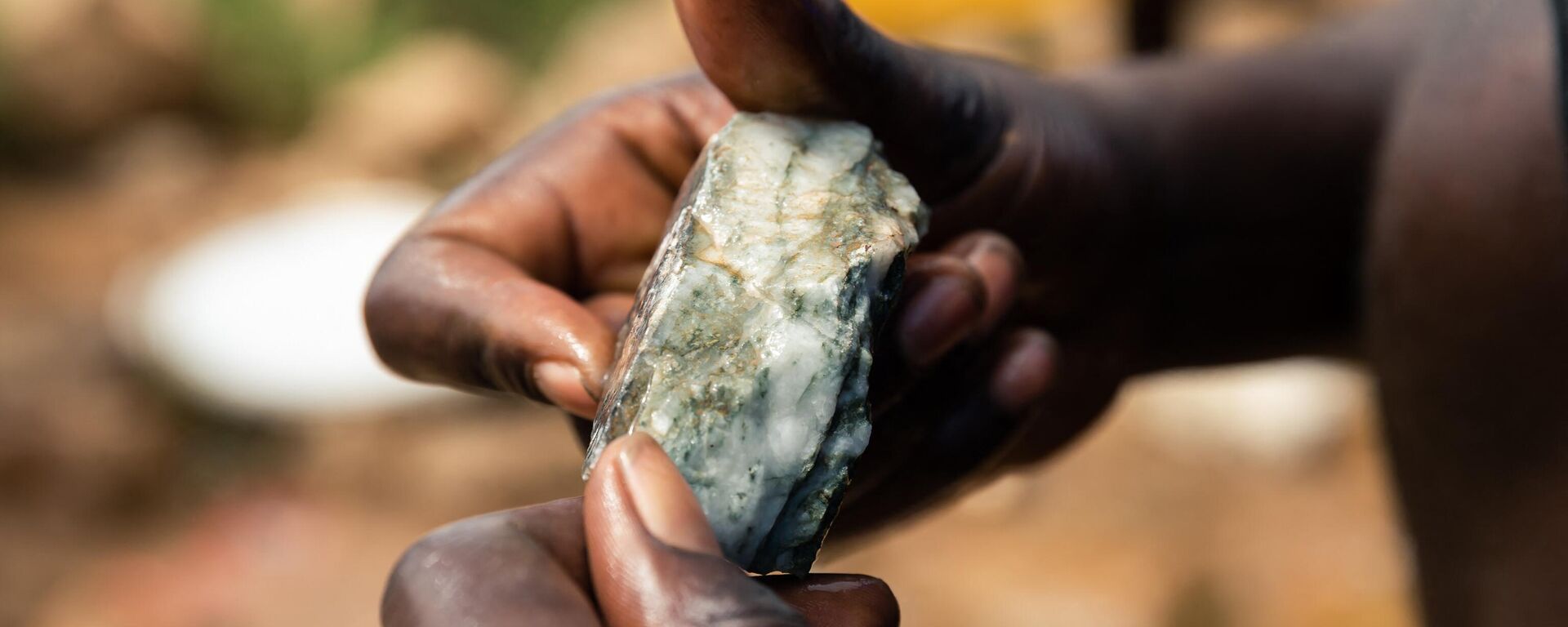 A young miner looks at an ore sample searching for gold during a mine search and rescue operation at Cricket Mine in Kadoma, Mashonaland West Province where more than 23 artisinal miners are trapped underground and feared dead on February 15, 2019.  - Sputnik Africa, 1920, 11.01.2023