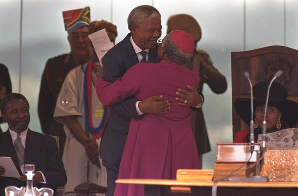 Mandela gets a hug from Archbishop Desmond Tutu of Capetown after Mandela was sworn in as president of South Africa. - Sputnik Africa