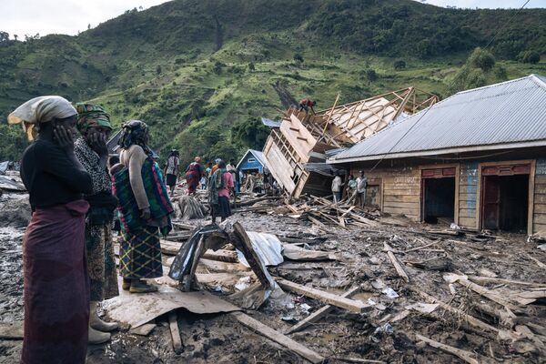 Residents of Nyamukubi stand, astonishedly looking at the rubble left in the wake of heavy flooding in the Democratic Republic of the Congo’s east, on May 6, 2023. Heavy downpours in the Kalehe region of South Kivu province on Thursday caused rivers to overflow, triggering landslides that engulfed the villages of Bushushu and Nyamukubi. - Sputnik Africa