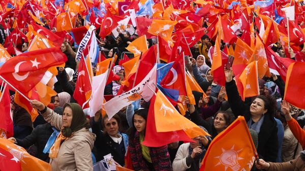 People waves Turkish and AK ruling party flags as they listen to Turkish President and People's Alliance's presidential candidate Recep Tayyip Erdogan during an election campaign rally in Ankara, Sunday, April 30, 2023. Presidential elections in Turkiye are scheduled to take place on May 14. - Sputnik Africa