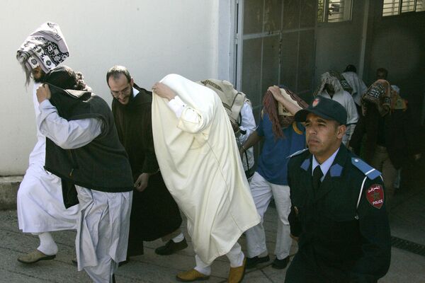 Moroccan Saad Houssaini (C, in white), one of the accused of allegedly fabricating explosives used in the May 2003 blasts in Casablanca leaves the court escorted by police in Sale, near Rabat, on 3 April 2008. - Sputnik Africa