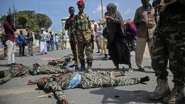 Somali security forces and civilians stand near the bodies of three suspected Shabaab fighters who were shot dead after exchanging fire with security forces outside the presidential palace in Mogadishu, on July 14, 2018 - Sputnik Africa