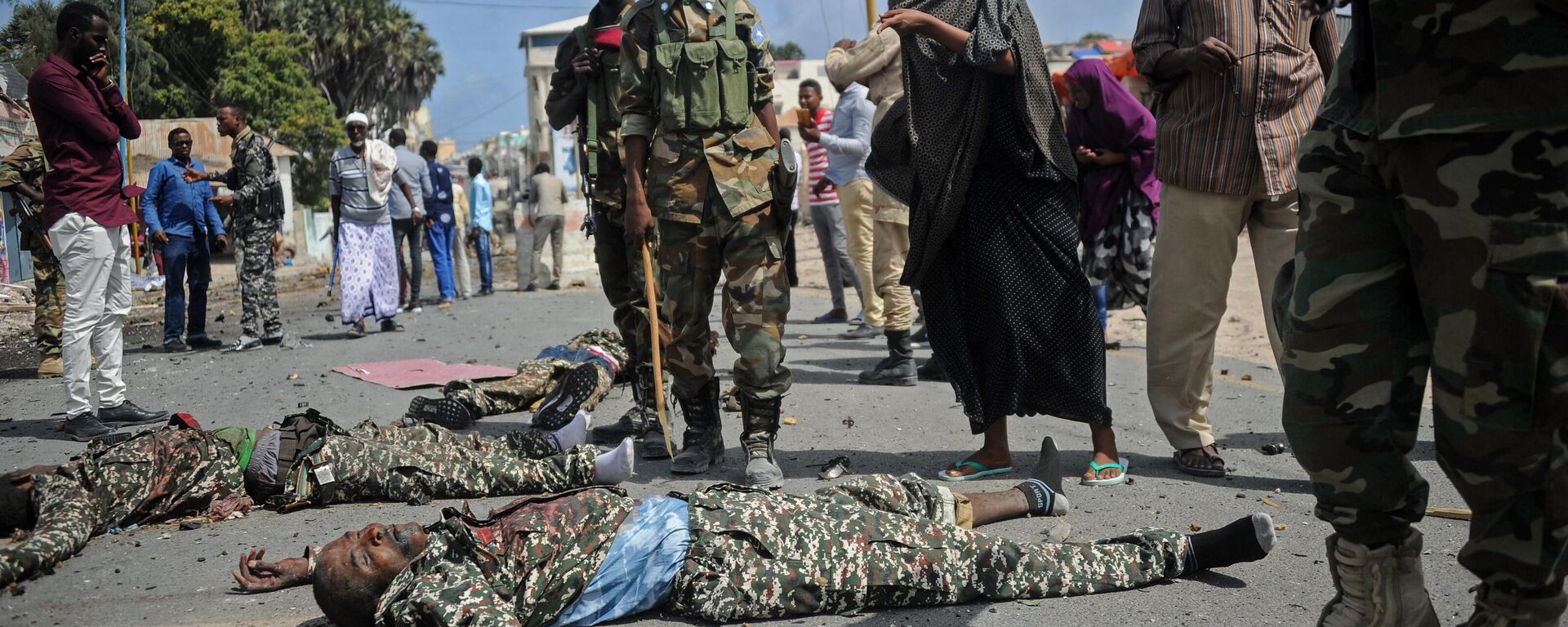 Somali security forces and civilians stand near the bodies of three suspected Shabaab fighters who were shot dead after exchanging fire with security forces outside the presidential palace in Mogadishu, on July 14, 2018 - Sputnik Africa, 1920, 14.05.2023