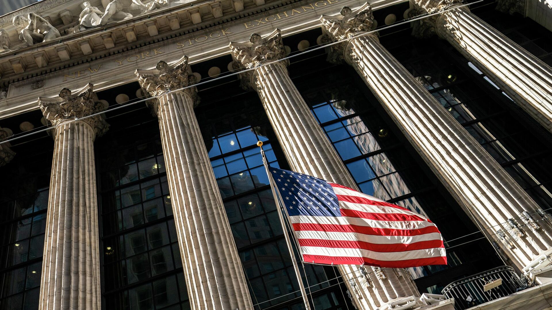 A U.S. flag waves outside the New York Stock Exchange, Monday, Jan. 24, 2022, in New York. Stocks are drifting between small gains and losses in the early going on Wall Street Tuesday, May 3, 2022 as investors await Wednesday's decision by the Federal Reserve on interest rates. The Fed is expected to raise its benchmark rate by twice the usual amount this week as it steps up its fight against inflation, which is at a four-decade high. - Sputnik Africa, 1920, 13.06.2023