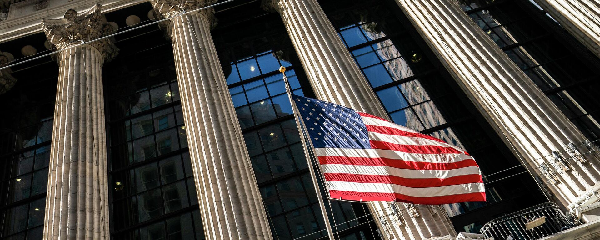 A U.S. flag waves outside the New York Stock Exchange, Monday, Jan. 24, 2022, in New York. Stocks are drifting between small gains and losses in the early going on Wall Street Tuesday, May 3, 2022 as investors await Wednesday's decision by the Federal Reserve on interest rates. The Fed is expected to raise its benchmark rate by twice the usual amount this week as it steps up its fight against inflation, which is at a four-decade high. - Sputnik Africa, 1920, 18.05.2023