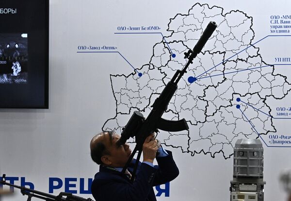 A visitor with a weapon at the 11th International exhibition of weapons and military equipment MILEX-2023 in Minsk. - Sputnik Africa