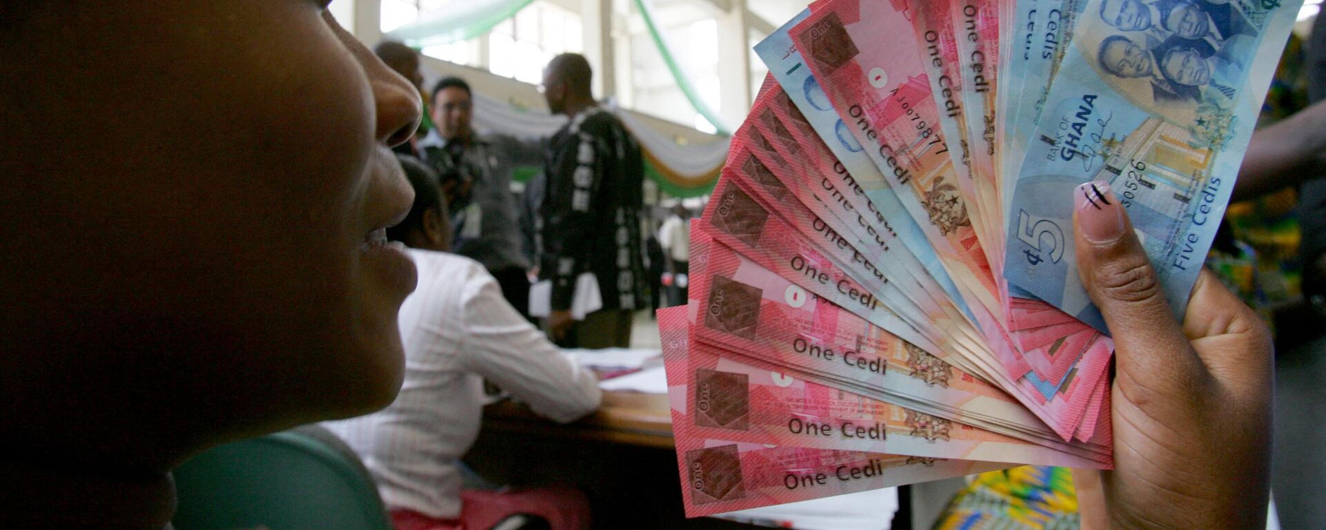 A woman in Accra holds a wad of new currency, the new cedi, which Ghana put into circulation on July 03, 2007, - Sputnik Africa, 1920, 18.05.2023