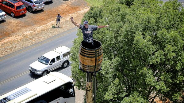 In this photo taken Nov. 14 2019, Henry Kruger waves from his wine barrel atop a pole in Dullstroom, South Africa, where he spent his 70th day, Friday Jan. 24, 2019. Kruger has broken his own record of 67 days set in 1997 according to the Guinness World Book of Records and continues his sitting feat.  - Sputnik Africa