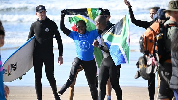 South African athlete Similo Dlamini celebrates with teammates after her heat on the first day of competition at the World Para Surfing Championship in Pismo Beach, California, on December 5, 2022.  - Sputnik Africa