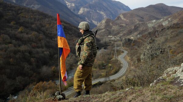 FILE - In this Wednesday, Nov. 25, 2020 file photo, An ethnic Armenian soldier stands guard next to Nagorno-Karabakh's flag atop of the hill near Charektar , Nov. 25, 2020 - Sputnik Africa