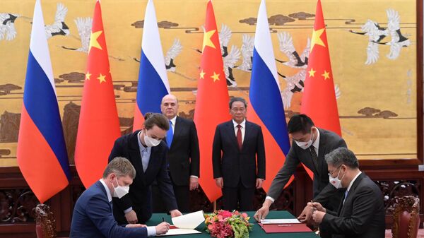 May 24, 2023. Russian Prime Minister Mikhail Mishustin, center right, and Premier of the State Council of the People's Republic of China Li Qiang at the signing ceremony of joint documents based on the results of Russian-Chinese talks at the House of People's Assemblies in Beijing. On the left is Russian Minister of Economic Development Maxim Reshetnikov. - Sputnik Africa