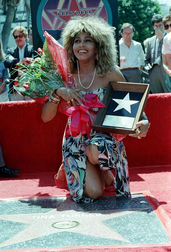 Rock and roll singer Tina Turner poses with her plaque and a bouquet of roses near her star on the Hollywood Walk of Fame during the unveiling ceremony in Los Angeles, California on August 28, 1986.   - Sputnik Africa