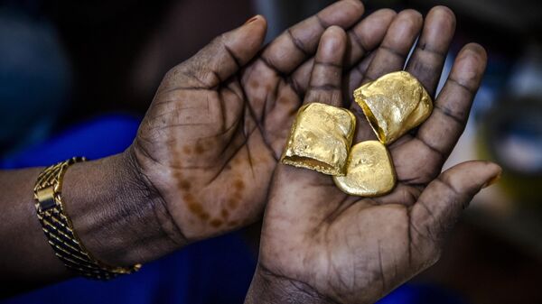 Tanzanian miner Assia Hussein, who is the chairman of an only-women miners association, observes some pure gold nuggets at a gold market in Geita, Tanzania on May 28, 2022.  - Sputnik Africa