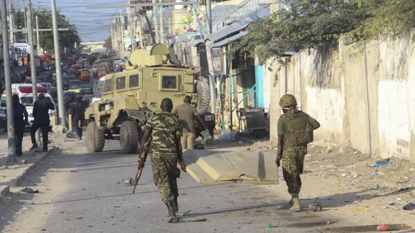 Des soldats de la Mission de l'Union africaine en Somalie (ATMIS) transportent l'épave d'un véhicule sur les lieux de l'attentat suicide qui a visé les forces à Mogadiscio, en Somalie, le 11 novembre 2021. - Sputnik Afrique