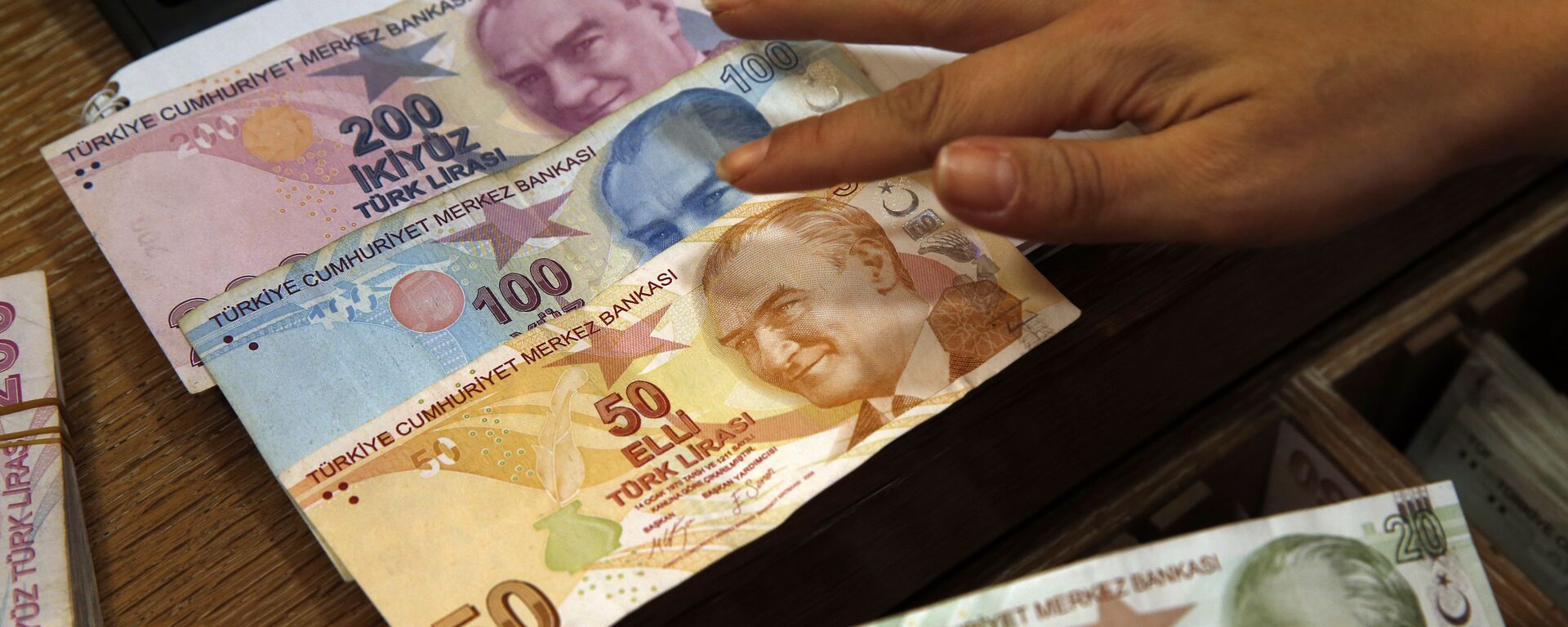 In this Wednesday, Aug. 15, 2018, file photo a worker at a currency exchange shop exhibits Turkish lira banknotes bearing pictures of modern Turkey's founder Mustafa Kemal Ataturk, in Istanbul.(file photo) - Sputnik Africa, 1920, 28.05.2023
