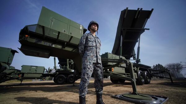 In this Jan. 18, 2018, file photo, a member of the Japan Ground Self-Defense Force stands guard next to a surface-to-air Patriot Advanced Capability-3 (PAC-3) missile interceptor launcher vehicle at Narashino Exercise Area in Funabashi, east of Tokyo.  - Sputnik Africa
