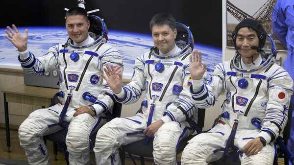 (From L) The Soyuz TMA-17M spacecraft International Space Station (ISS) crew of US astronaut Kjell Lindgren, Russian cosmonaut Oleg Kononenko and Japanese astronaut Kimiya Yui wave during a space suit testing before leaving for a launch pad of the Russian-leased Baikonur cosmodrome in Kazakhstan on July 22, 2015 a few hours before a blast off - Sputnik Africa