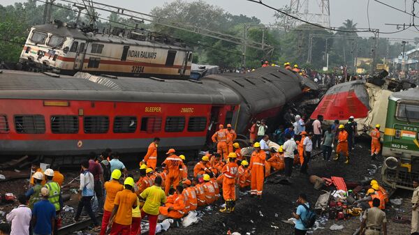 Rescue workers gather around damaged carriages at the accident site of a three-train collision near Balasore, about 200 km (125 miles) from the state capital Bhubaneswar in the eastern state of Odisha, on June 3, 2023. At least 288 people were killed and more than 850 injured in a horrific three-train collision in India, officials said on June 3, the country's deadliest rail accident in more than 20 years. (Photo by Dibyangshu SARKAR / AFP) - Sputnik Africa