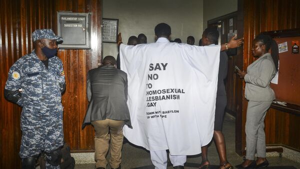 Ugandan MP John Musila wears clothes with an anti-LGBTQ message as he enters the Parliament to vote on a new anti-gay bill, on March 21, 2023. - Sputnik Africa