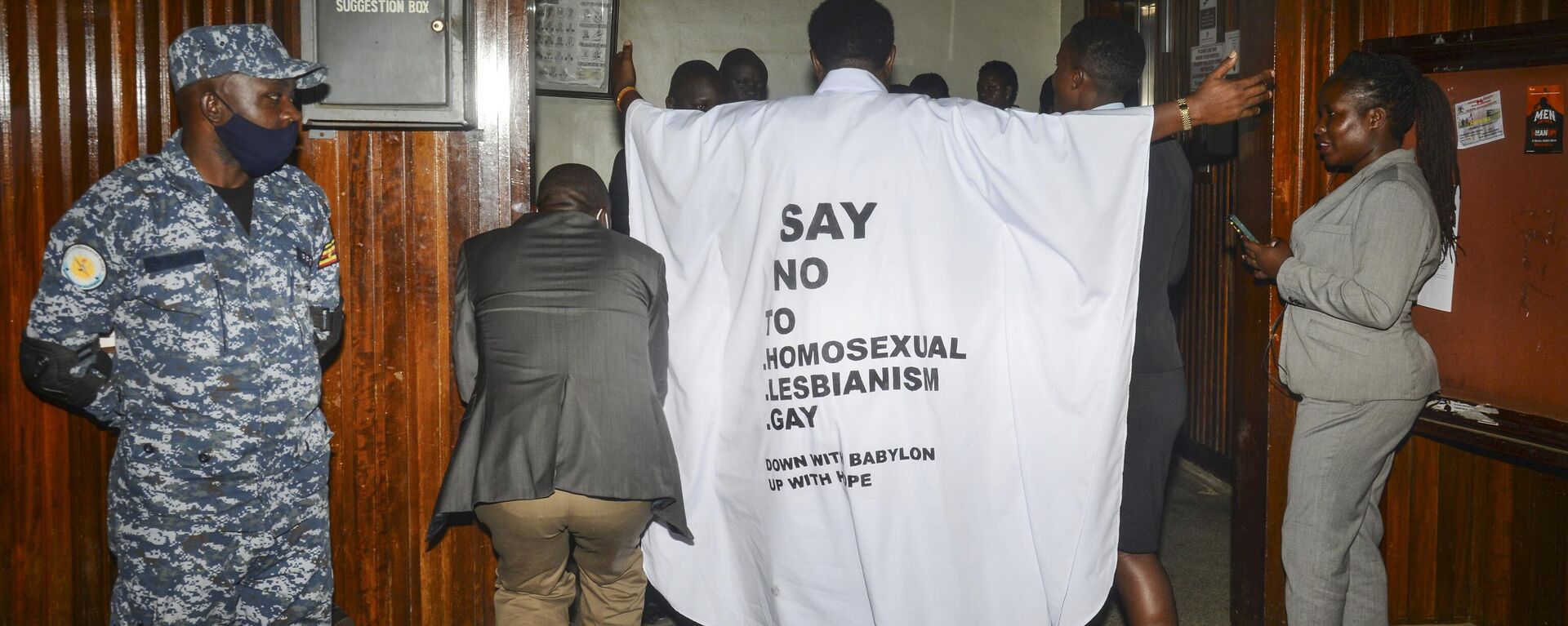 Ugandan MP John Musila wears clothes with an anti-LGBTQ message as he enters the Parliament to vote on a new anti-gay bill, on March 21, 2023. - Sputnik Africa, 1920, 03.06.2023