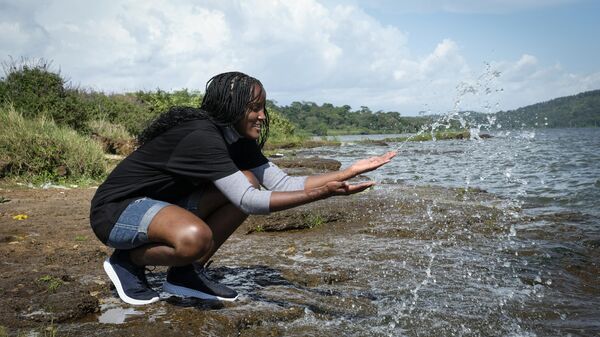 Ugandan climate activist Vanessa Nakate splashes the water as she explains the changing water levels of Lake Victoria, on the outskirts of Kampala, Uganda Monday, Dec. 6, 2021. - Sputnik Africa