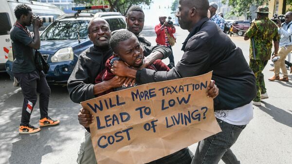 Kenyan plain clothed police officers detain an activist during a protest over tax hike plans in Nairobi on June 6, 2023 - Sputnik Africa