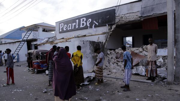 Somalis stand outside the destroyed Pearl Beach hotel in Mogadishu, Somalia - Sputnik Africa