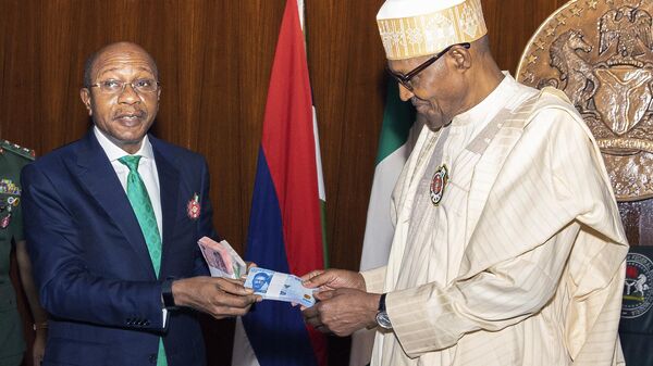In this photo released by the Nigeria State House, Nigeria's Central Bank governor, Godwin Emefile, left, presents the newly designed currency notes to Nigeria's President Muhammadu Buhari, right, during a launch in Abuja, Nigeria, Tuesday, Nov. 22, 2022.  - Sputnik Africa