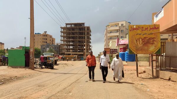 People walk past stores in Khartoum on June 9, 2023, amid ongoing fighting.  - Sputnik Africa