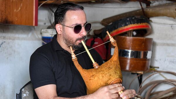In this picture taken on May 24, 2023, Tunisian musician Montassar Jebali, who plays several jazz and hip-hop ensembles, tests a mizwad instrument at a traditional workshop in the locality of Jedaida near Tunis.  - Sputnik Africa
