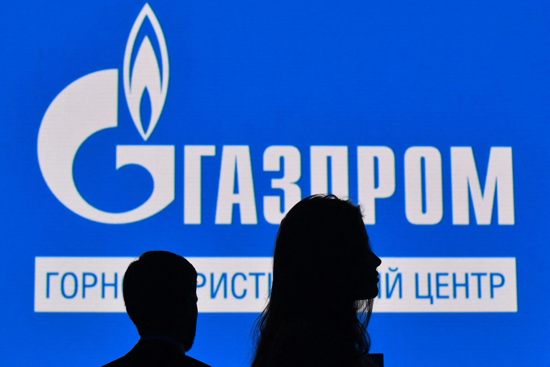 Participants walk in front of a large screen displaying the logo of Russia's energy giant Gazprom during the St. Petersburg International Gas Forum (SPIGF) in Saint Petersburg on September 15, 2022. - Sputnik Africa, 1920, 31.05.2023