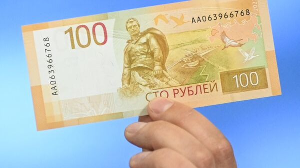 Russia's Central Bank official shows an updated version of 100-rubles banknote .  - Sputnik Africa