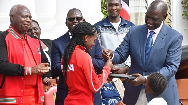 Kenyan President William Ruto presents the keys to a new home to runner Faith Kipyegon - Sputnik Africa
