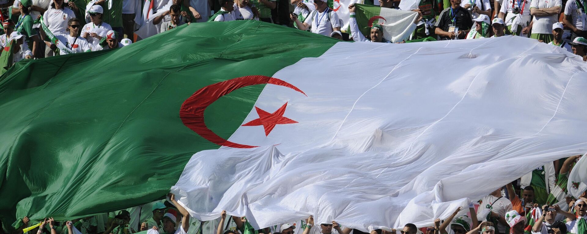 Algerian fans unfurl a giant Algerian flag during their Group C first round 2010 World Cup football match on June 13, 2010 at Peter Mokaba stadium in Polokwane. - Sputnik Africa, 1920, 23.06.2023