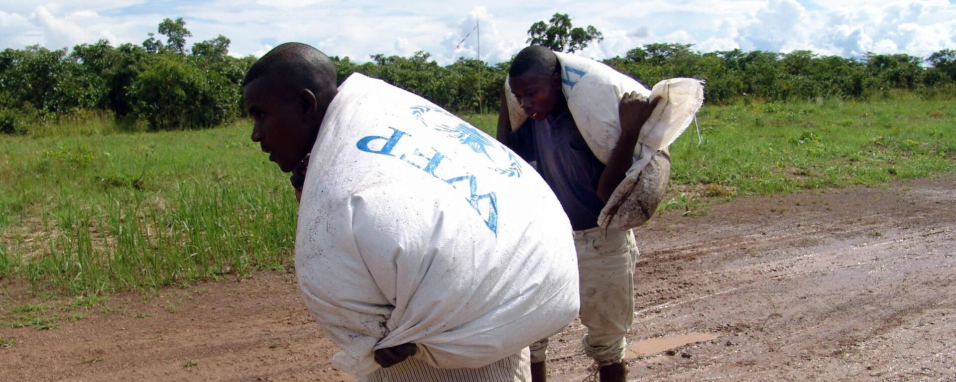 Villagers in Sampwe, Katanga, carry bags full of WFP food aid airdropped in the morning, 15 April 2006. - Sputnik Africa, 1920, 20.06.2023
