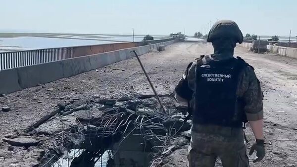 In this video grab a Russian Investigative Committee serviceman stands on a bridge damaged during the Ukrainian armed forces' attack, on the administrative border between the Kherson Region and the Crimea near the village of Chongar, Crimea, Russia. - Sputnik Africa